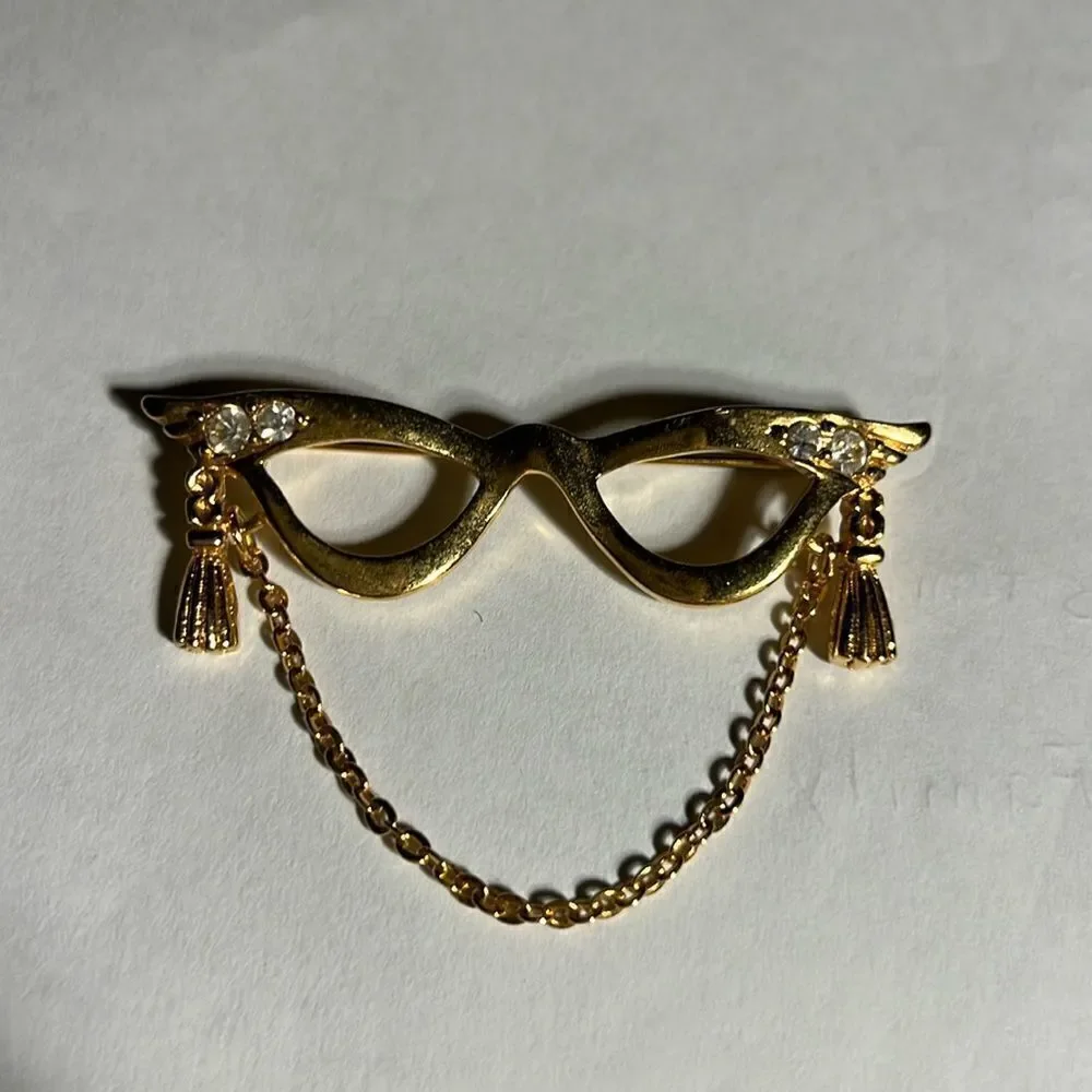 Avon golden eyeglass holder brooch with gold tassel.